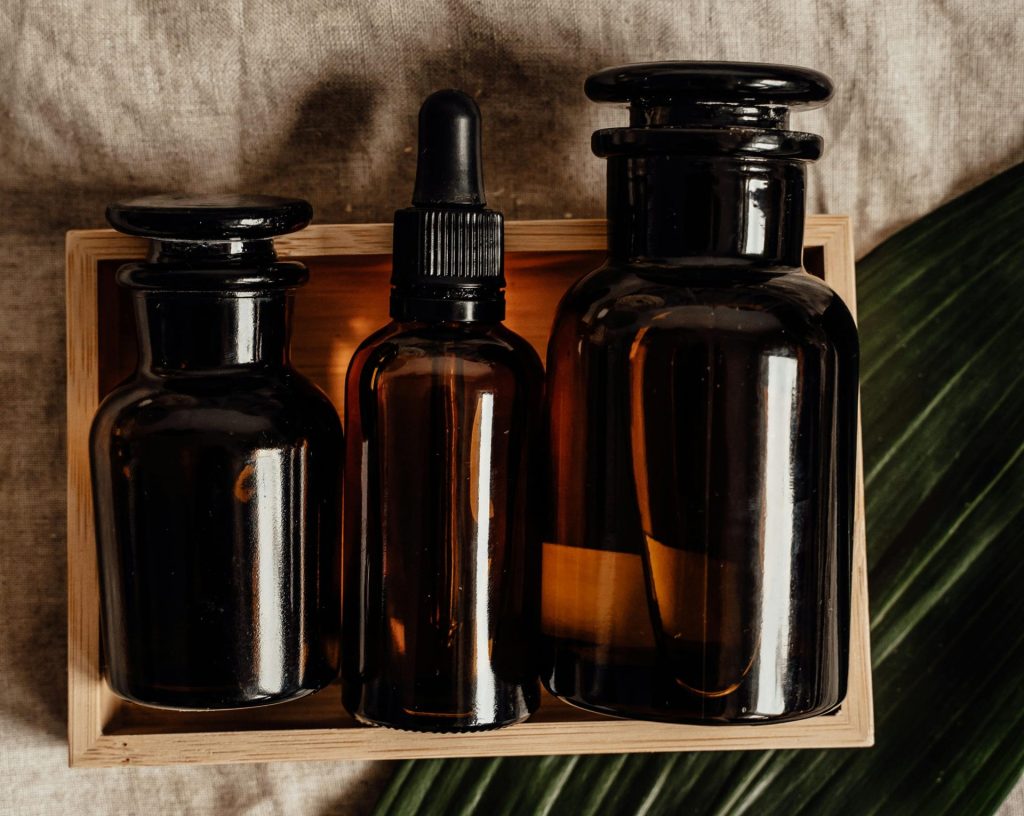 Elegant glass bottles with essential oils arranged on a linen surface, providing a rustic and natural look.